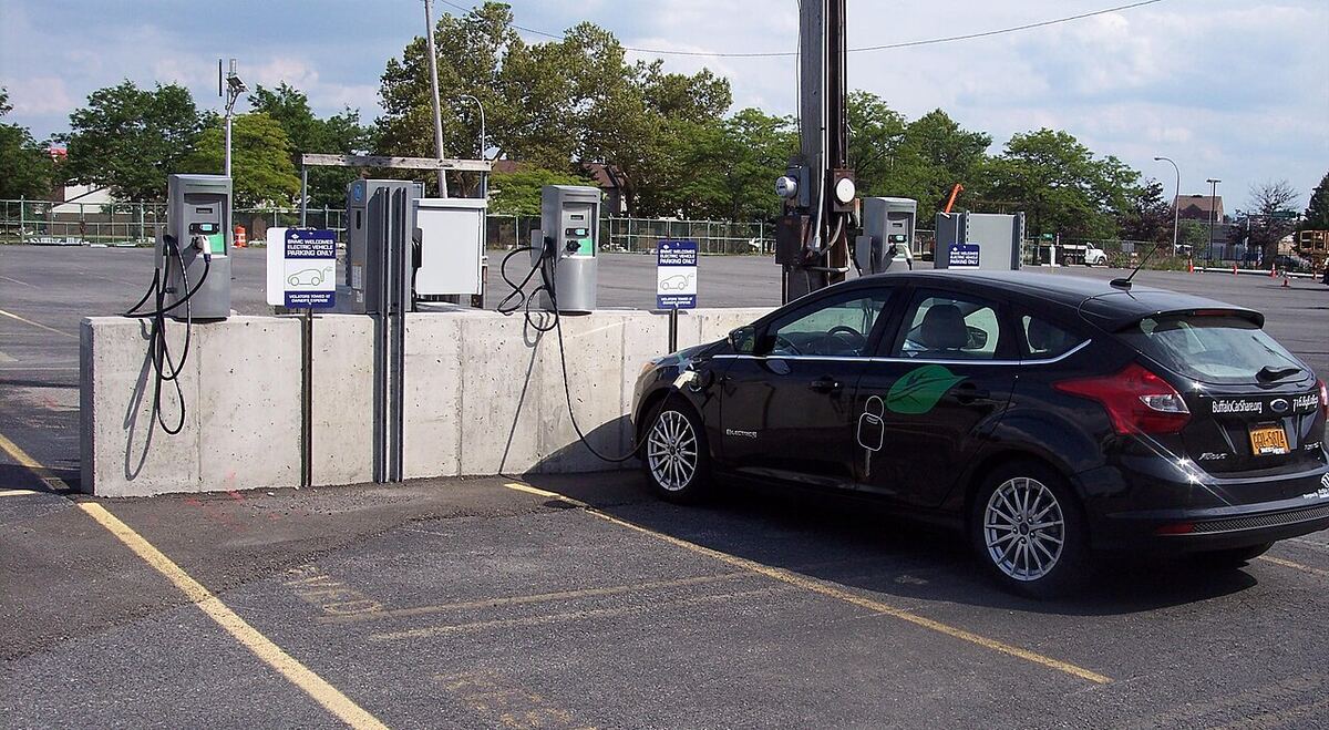 Station de recharge sur un parking avec une voiture en charge